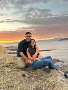 Pareja feliz a la orilla del mar en una puesta del sol